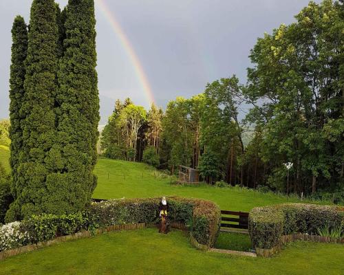 a woman standing in a garden with a rainbow in the background at Apartment in Mölbling/Kärnten 69 in Althofen