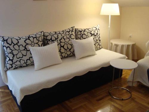 a bed with pillows and a table in a room at Apartment in Zadar/Zadar Riviera 7837 in Smirić