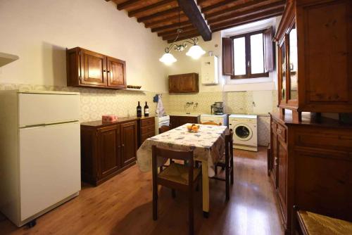 uma cozinha com uma mesa e um frigorífico branco em Apartment in Montepulciano/Toskana 24058 em Montepulciano