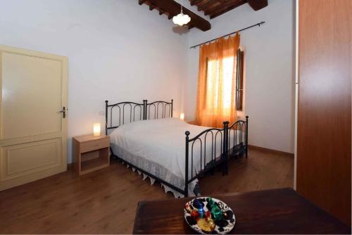 um quarto com uma cama, uma mesa e uma janela em Apartment in Montepulciano/Toskana 24058 em Montepulciano