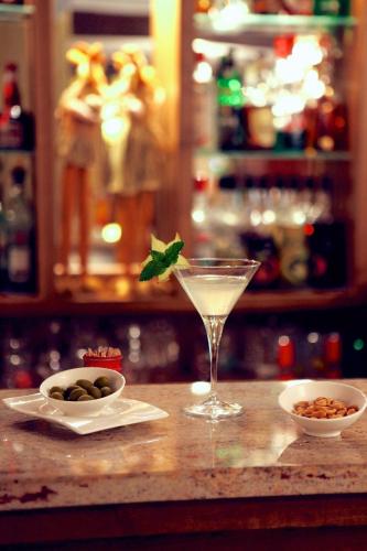 a drink sitting on a counter next to a bowl of nuts at Logis Hotel Restaurant La Porte des Cévennes in Anduze