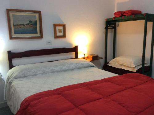 a bedroom with a large bed with a red blanket at Piccolo Borgo Antico - Casina delle Rondini in Campos do Jordão