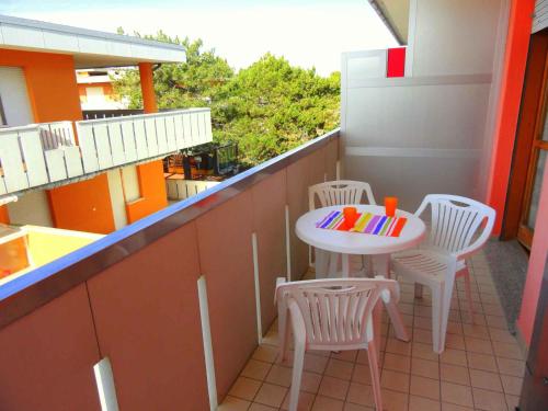a small balcony with a table and chairs on it at Apartments in Bibione 24565 in Bibione