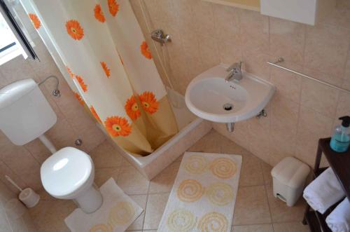 a bathroom with a toilet and a sink and a shower at Palit Apartment 1 in Palit