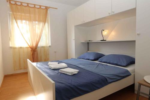 a bedroom with a bed with blue sheets and blue pillows at Silo Apartment 17 in Šilo