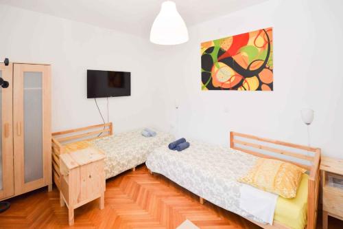 a bedroom with two beds and a tv on the wall at Apartment Pula 43 in Veruda