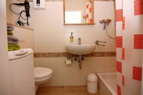 ein Badezimmer mit einem Waschbecken, einem WC und einer Badewanne in der Unterkunft Wendtorf Apartment 1 in Wendtorf