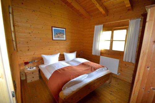 ein Schlafzimmer mit einem Bett in einem Blockhaus in der Unterkunft Holiday home in Kaltenbach/Zillertal 874 in Kaltenbach