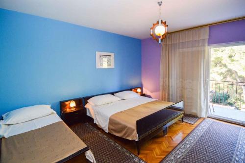 a bedroom with a bed and a blue wall at Two-Bedroom Apartment in Pula IX in Veruda