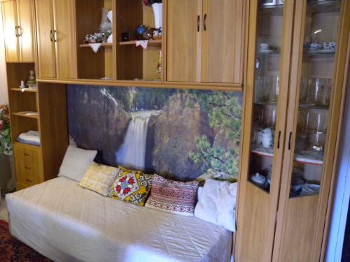 a bedroom with wooden cabinets and a bed with pillows at Apartment Balatonbereny 1 in Balatonberény