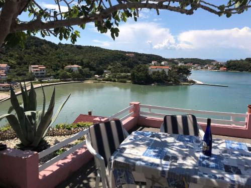 a table and chairs with a view of a body of water at Apartment in Supetarska Draga 17854 in Supetarska Draga