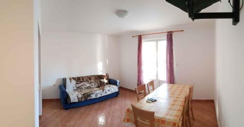 Apartment Lopar 4 في لوبار: غرفة معيشة مع طاولة وكرسي
