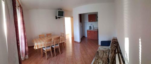 Apartment Lopar 4 في لوبار: مطبخ وغرفة طعام مع طاولة وكراسي
