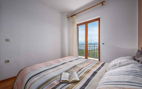 a bedroom with a bed with two books on it at Apartment Drenje 5 in Drenje