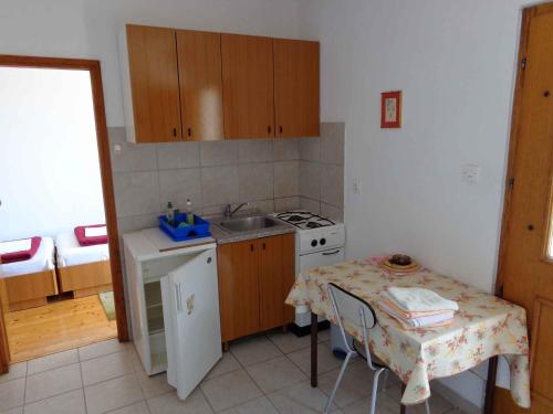 a small kitchen with a table and a sink at Apartment Sv. Marina 1 in Sveta Marina