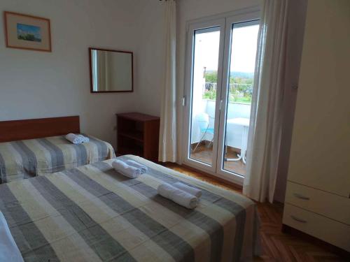 a bedroom with two beds and a large window at Apartment Ljubac 21 in Ljubač