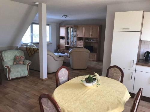 eine Küche und ein Wohnzimmer mit einem Tisch und Stühlen in der Unterkunft Apartment Gingst 1 in Haidhof