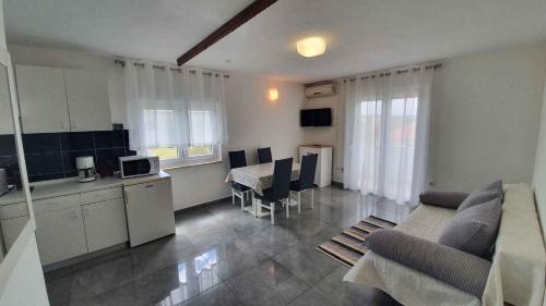 ein Wohnzimmer mit einem Sofa und eine Küche mit in der Unterkunft Apartment Ljubac 1 in Krneša