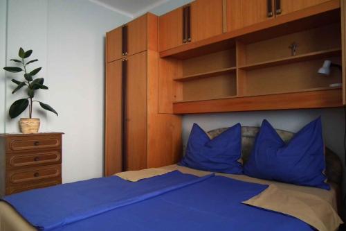 バラトンレッレにあるTwo-Bedroom Apartment Balatonlelle near Lake 1のベッドルーム1室(青い枕とキャビネット付)