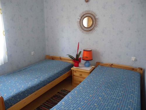 two twin beds in a room with a mirror at Holiday home in Balatonfenyves 18412 in Balatonfenyves