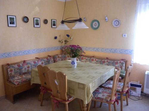 バラトンフェニヴェシュにあるHoliday home in Balatonfenyves 18412のダイニングルームテーブル(椅子付)、花瓶