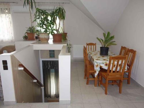 a dining room with a table and chairs and plants at Apartment Balatonfenyves/Balaton 18408 in Balatonfenyves