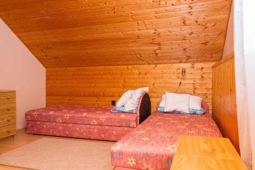 バラトンフェニヴェシュにあるHoliday home in Balatonfenyves 18368の木製の壁のベッドルーム1室(ベッド2台付)