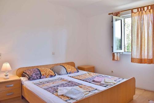 a bedroom with a large bed with a window at Apartment Lopar, Primorje-Gorski Kotar 6 in Lopar