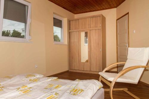 バラトンケレストゥールにあるHoliday home Balatonkeresztur 24のベッドルーム1室(ベッド1台、椅子、窓付)