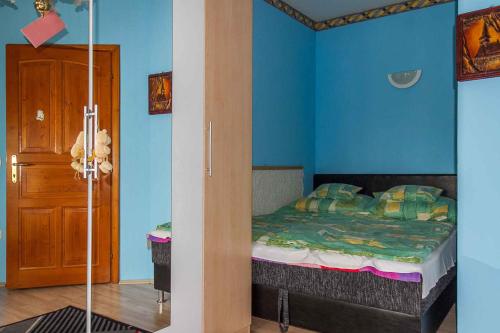 BalatonújlakにあるHoliday home in Balatonmariafürdo 19257のベッドルーム1室(青い壁のベッド1台付)