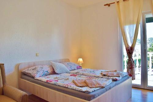 1 dormitorio con 1 cama con mantas y almohadas en Apartment in Lopar - Insel Rab 17739, en Lopar