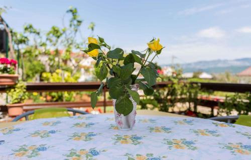 a vase filled with yellow roses sitting on a table at Apartment in Silo/Insel Krk 13509 in Šilo