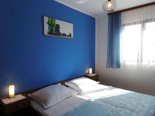 a bedroom with a blue wall and a bed at Apartment in Valbandon/Istrien 11260 in Valbandon