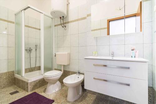 een badkamer met een toilet, een douche en een wastafel bij Apartment Rabac 10 in Rabac