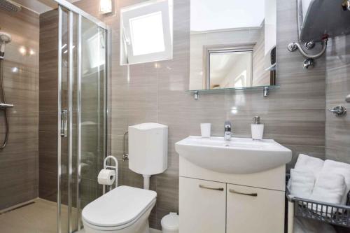 a bathroom with a toilet and a sink and a shower at Holiday home Medulin 21 in Medulin