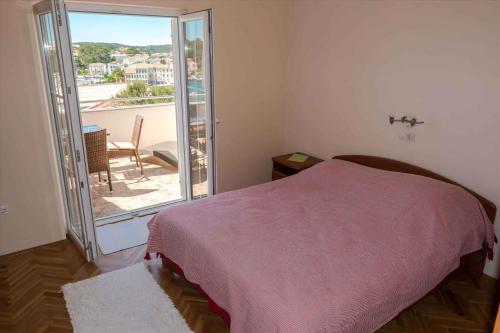 um quarto com uma cama e vista para uma varanda em Apartment Banjol 23 em Rab