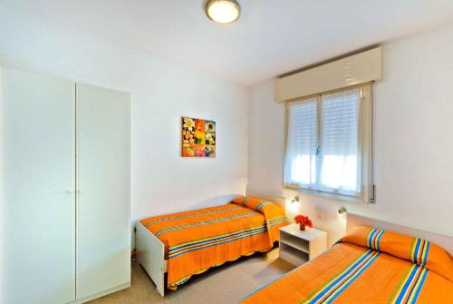 ビビオーネにあるApartments in Bibione 25584のベッドルーム1室(ベッド2台、窓付)