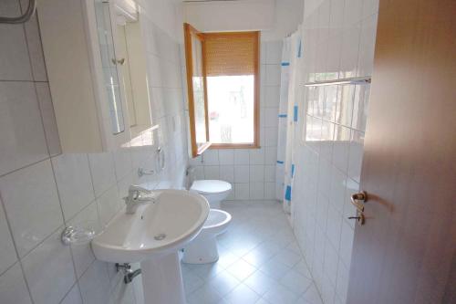 ロザピネタにあるApartments in Rosolina Mare 24864の白いバスルーム(洗面台、トイレ付)