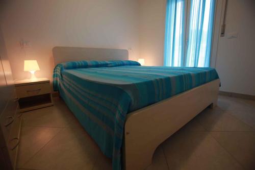 ロゾリーナ・マーレにあるTwo-Bedroom Apartment Rosolina Mare near Sea 3のベッドルーム1室(青い毛布付きのベッド1台付)