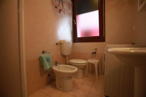 ロザピネタにあるApartment Rosolina Mare 21のバスルーム(トイレ、洗面台付)、窓が備わります。