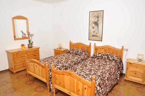 a bedroom with two beds and two dressers and a mirror at Apartment Pieve di Ledro 3 in Ledro