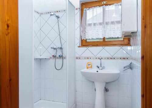 y baño blanco con lavabo y ducha. en Holiday home in Balatonmariafürdo 19539, en Balatonkeresztúr