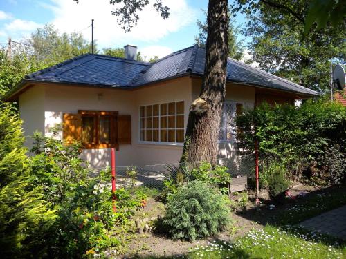 mały domek z drzewem przed nim w obiekcie Holiday home in Balatonfenyves 18357 w mieście Balatonfenyves