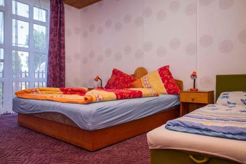 um quarto com 2 camas com almofadas vermelhas e amarelas em Holiday home in Balatonmariafürdo 19511 em Balatonmáriafürdő