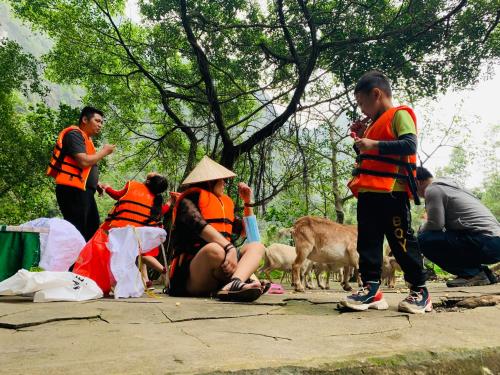 a group of people in orange vests with animals at Tuan Nam Homestay in Ninh Binh