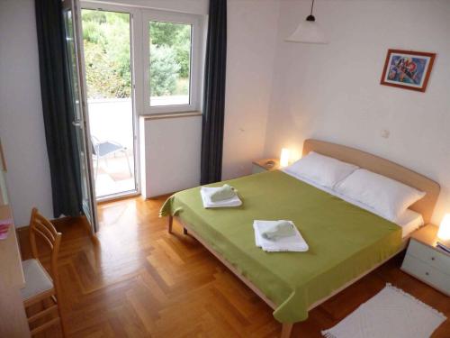 - une chambre avec un lit et 2 serviettes dans l'établissement Apartment Barbat 8, à Barbat na Rabu