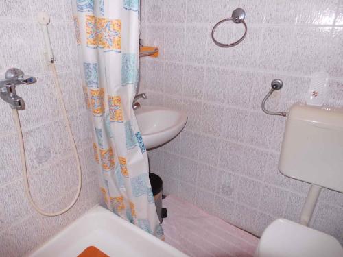 bagno con tenda per la doccia e servizi igienici di Apartment Zadar, Zadar County 8 a Smirić
