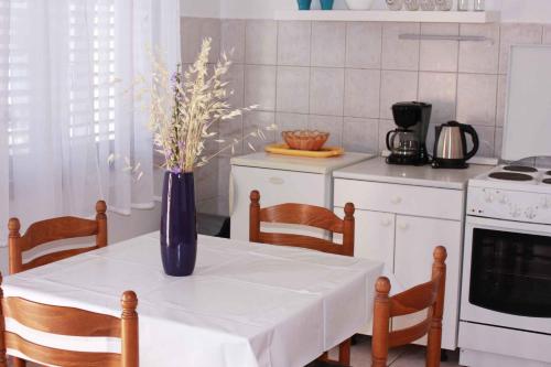 a kitchen with a table with a vase of flowers on it at One-Bedroom Apartment Novi Vinodolski near Sea 7 in Povile
