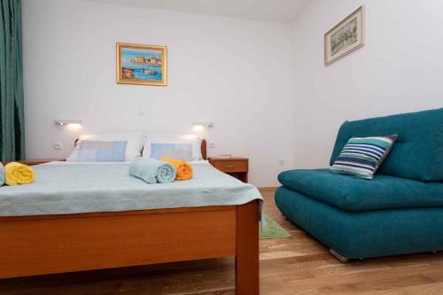 a bedroom with a bed and a blue couch at Apartment in Silo/Insel Krk 13438 in Šilo