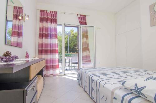 a white bedroom with a bed and a balcony at Apartment in Krk/Insel Krk 12637 in Krk